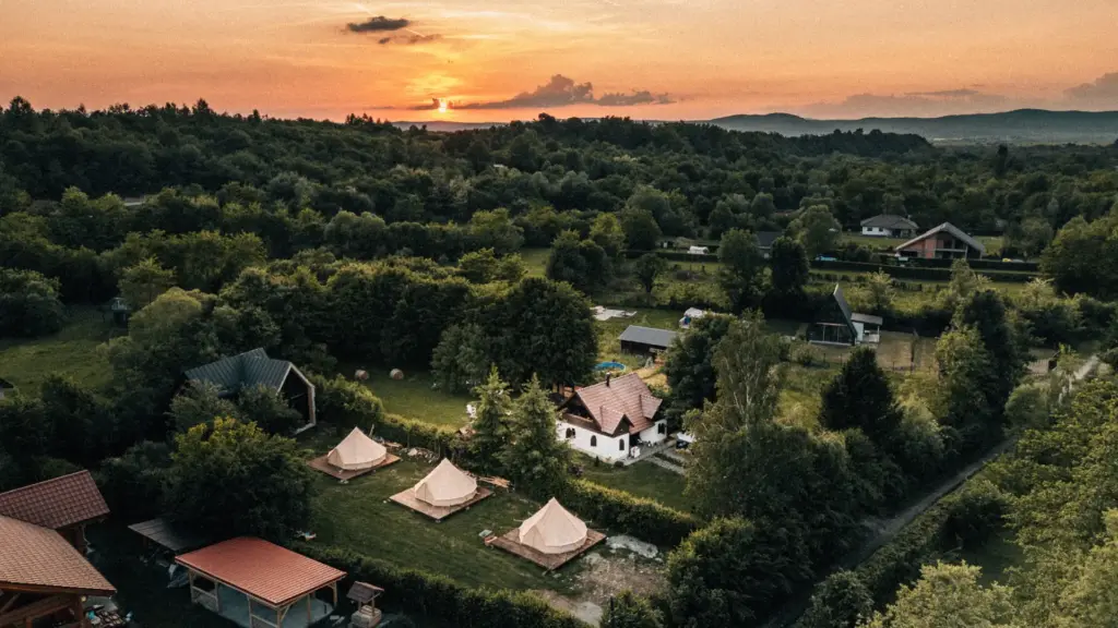 Hotel és panzió weboldal Légifelvétel egy harangsátrakból álló glampingről naplementekor Romániában